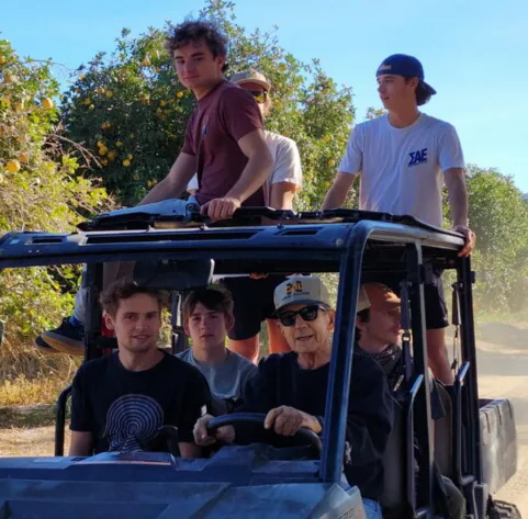 Seley family members riding a utility vehicle through the citrus orchard